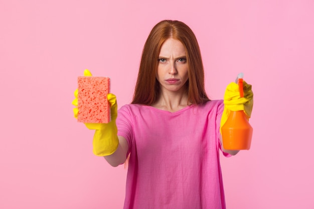 Giovane donna con i capelli rossi in guanti di gomma gialli