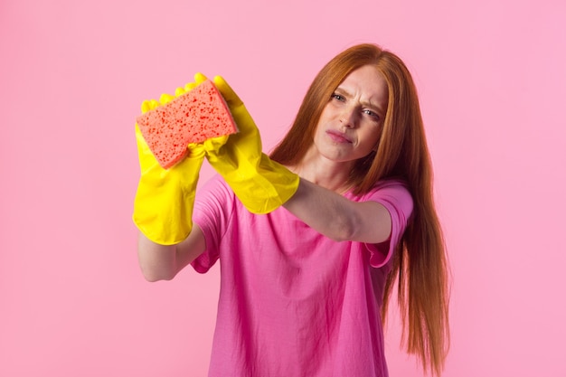 Giovane donna con i capelli rossi in guanti di gomma gialli