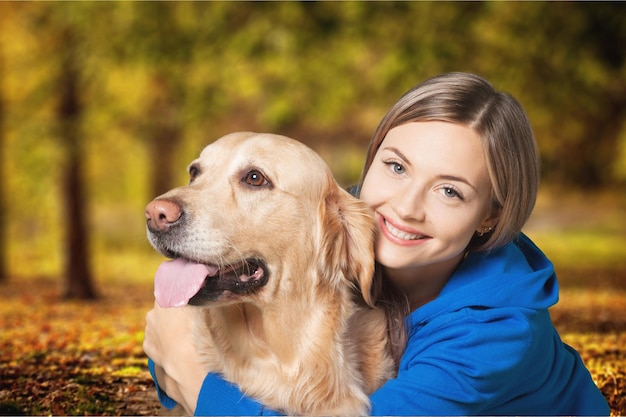 Giovane donna con il cane su sfondo sfocato