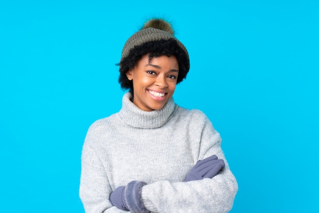 Giovane donna con il cappello di inverno sopra la parete isolata