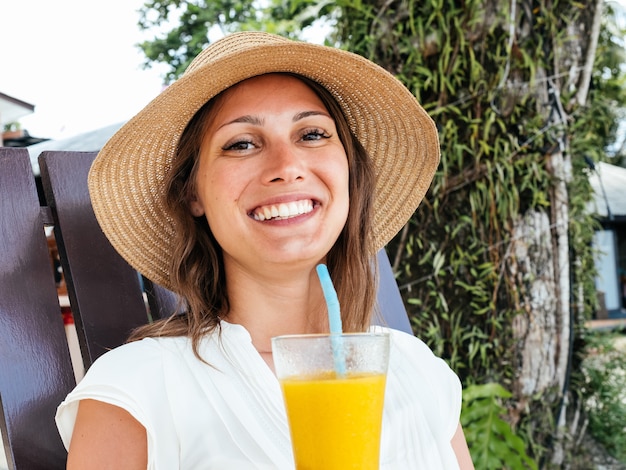 Giovane donna con il cocktail rinfrescante della bevanda del cappello