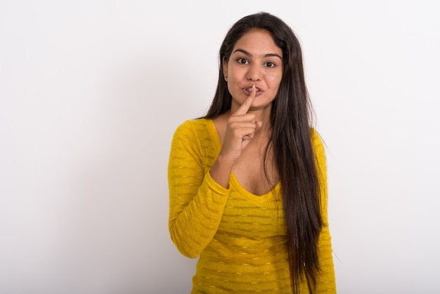 Giovane donna con il dito sulle labbra