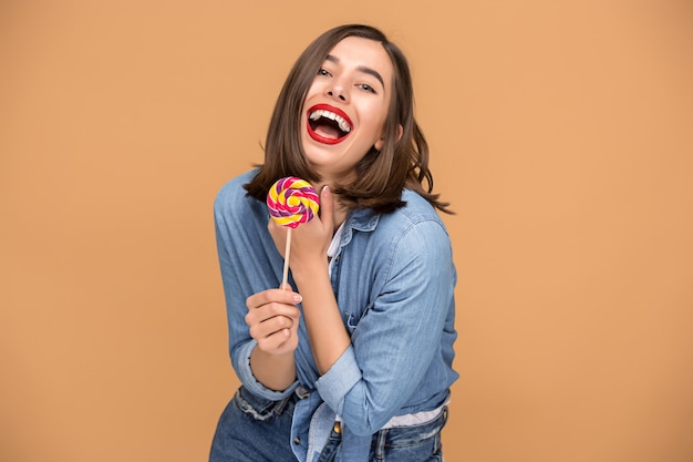 Giovane donna con il lecca-lecca colorato in studio