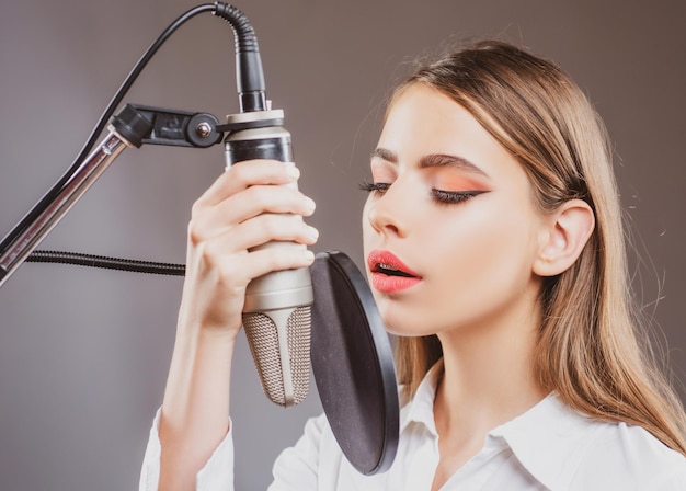 Giovane donna con il microfono che canta il musicista di una canzone nel music hall divertente adolescente che canta al karaoke