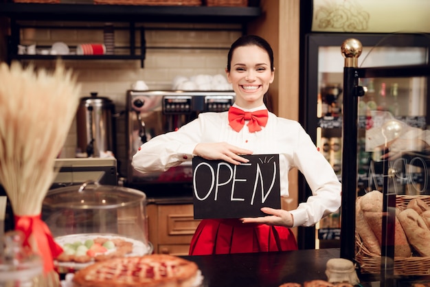 Giovane donna con il segno aperto che sta in forno.