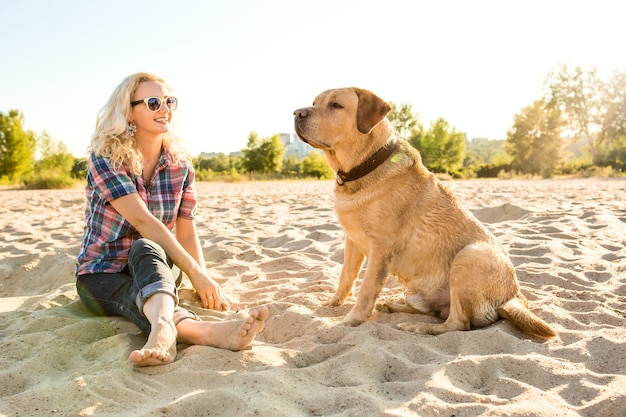 Giovane donna con il suo cane in spiaggia