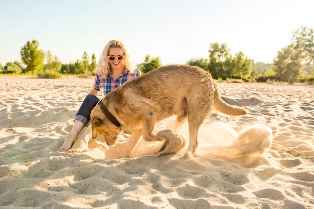 Giovane donna con il suo cane in spiaggia