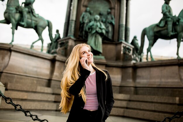 Giovane donna con il telefono cellulare sulla strada di Vienna, Austria