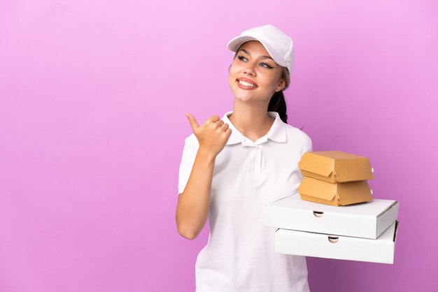 Giovane donna con insalata su sfondo blu isolato