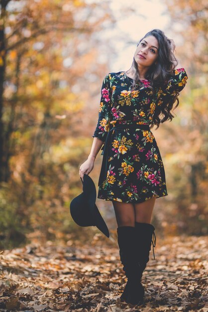 Giovane donna con l'ombrello in autunno