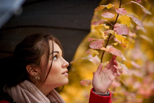 Giovane donna con l&#39;ombrello nella sosta di autunno