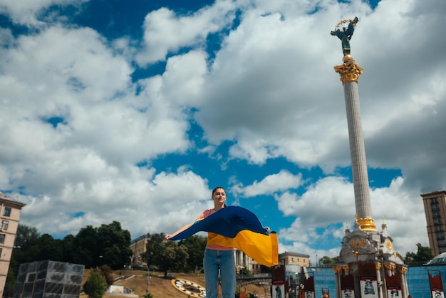 Giovane donna con la bandiera nazionale dell'Ucraina sulla strada