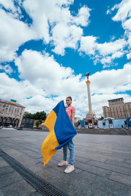 Giovane donna con la bandiera nazionale dell'Ucraina sulla strada