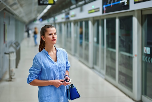 Giovane donna con la borsetta nella stazione della metropolitana.