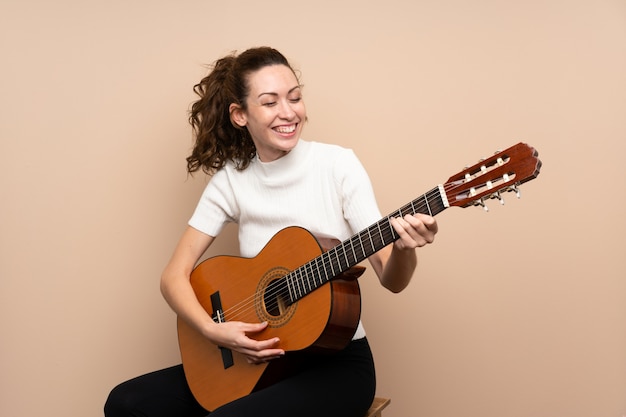 Giovane donna con la chitarra sopra isolata