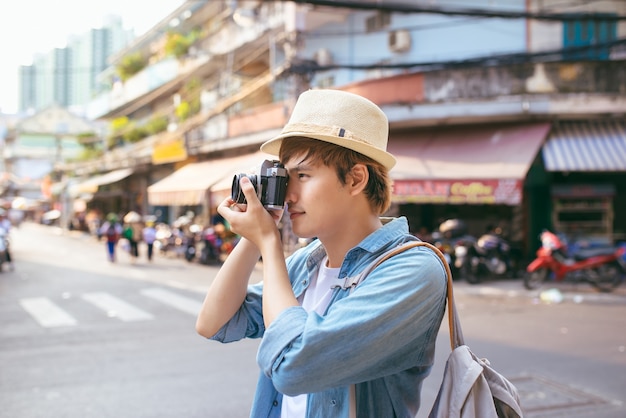 Giovane donna con la macchina fotografica che fotografa in strada