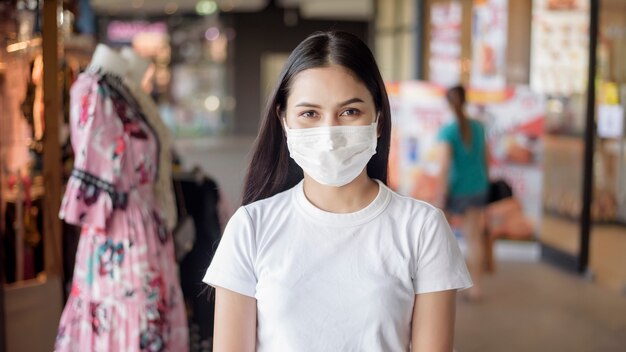 Giovane donna con la maschera che sta all'aperto