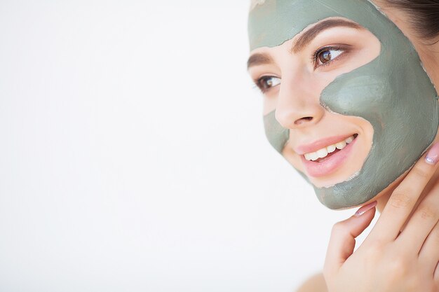 Giovane donna con la maschera cosmetica dell'argilla