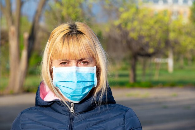 Giovane donna con la maschera per il viso. Nuovo concetto di coronavirus cinese di autoprotezione