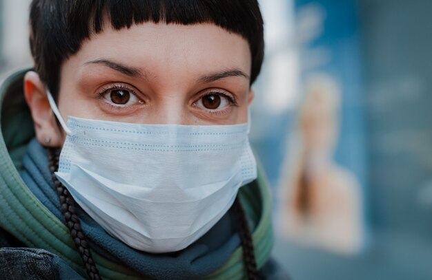 Giovane donna con la maschera per le strade. Protezione dal coronavirus