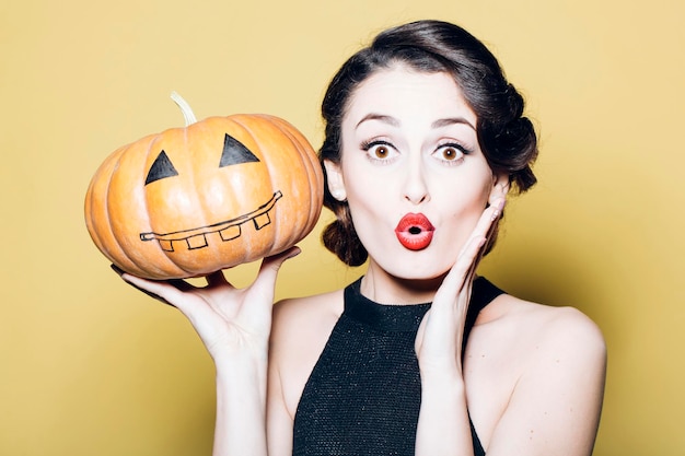 Giovane donna con la zucca di Halloween