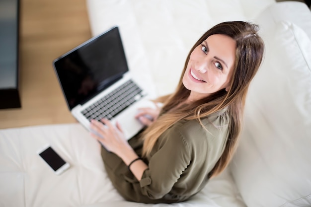 Giovane donna con laptop e telefono cellulare