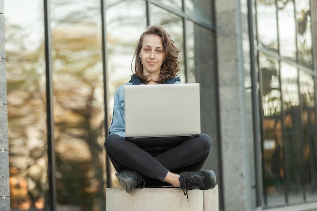 Giovane donna con laptop in città