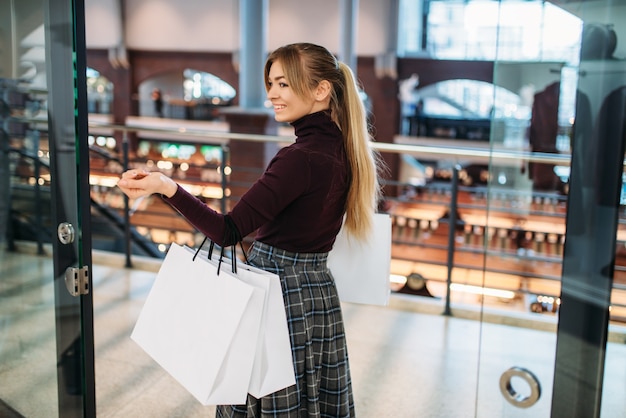 Giovane donna con le borse della spesa nel centro commerciale