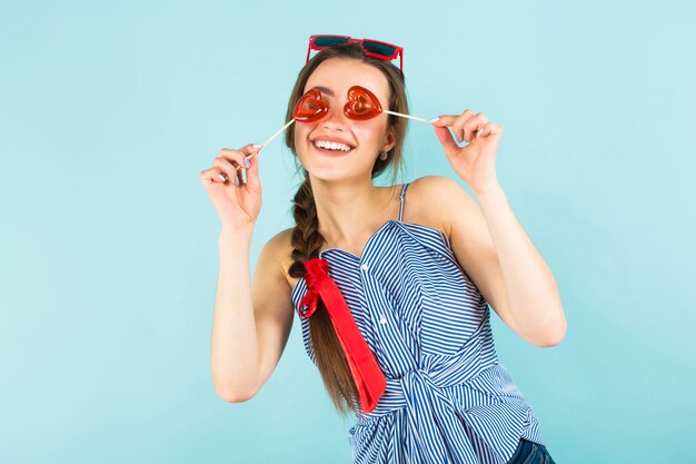 Giovane donna con lecca-lecca a forma di cuore