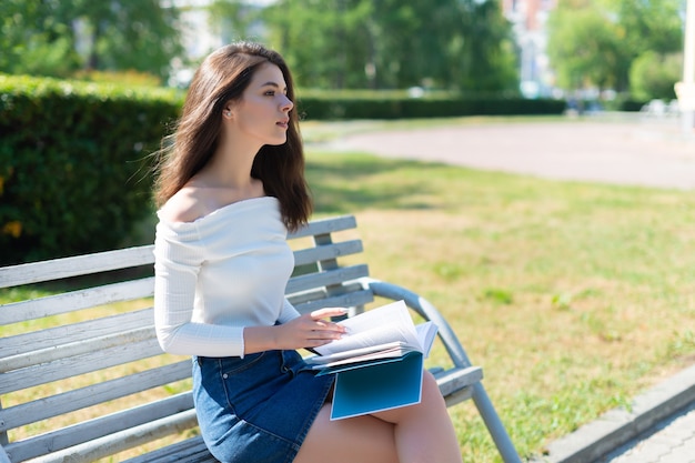 Giovane donna con libri nel parco