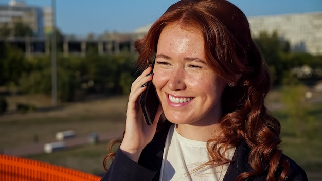 Giovane donna con macchie sul viso parla al telefono sopra street