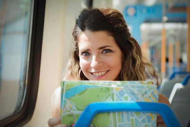 Giovane donna con mappa viaggiando in treno. Stile di vita delle persone