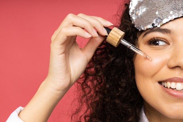 Giovane donna con maschera per dormire su sfondo rosa