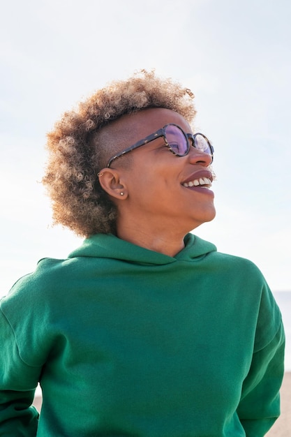 Giovane donna con occhiali e capelli afro che ride