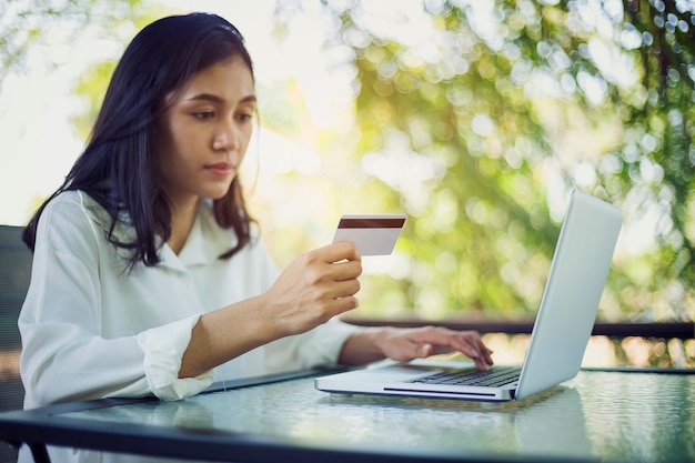 Giovane donna con pagamento con carta di credito da shopping online
