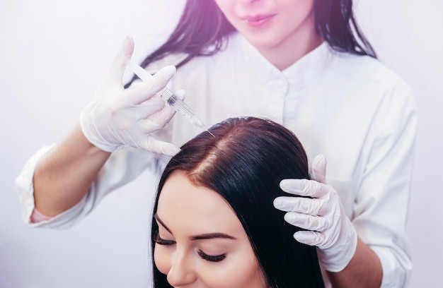 Giovane donna con problema di perdita di capelli che riceve l'iniezione, primi piani