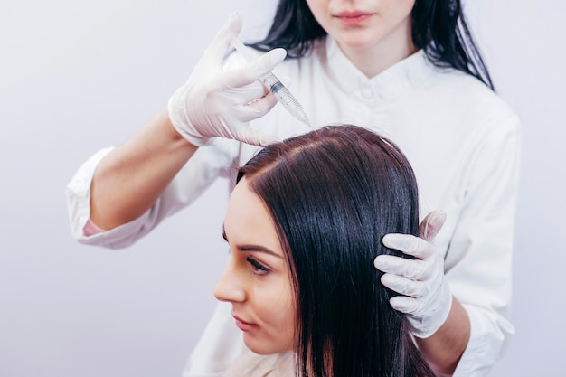 Giovane donna con problema di perdita di capelli che riceve l'iniezione, primi piani