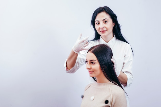 Giovane donna con problema di perdita di capelli che riceve l'iniezione, primi piani