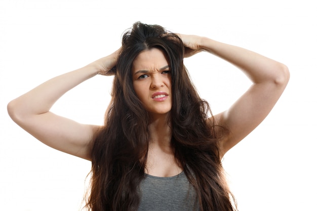 Giovane donna con problemi di capelli. Su bianco isolato