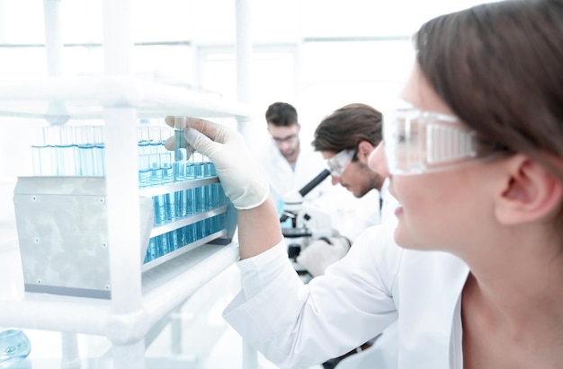 Giovane donna con provette in laboratorio