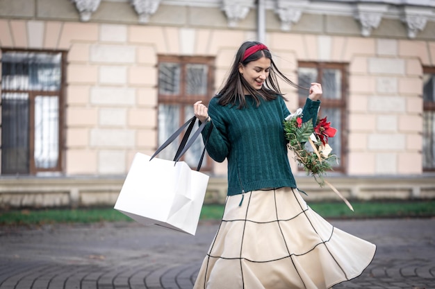 Giovane donna con regali di natale fuori dagli acquisti di natale