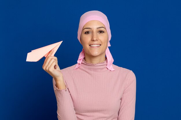 Giovane donna con sciarpa rosa sulla testa su un blu