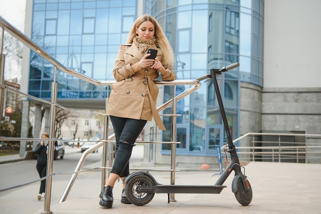 Giovane donna con scooter elettrico in città