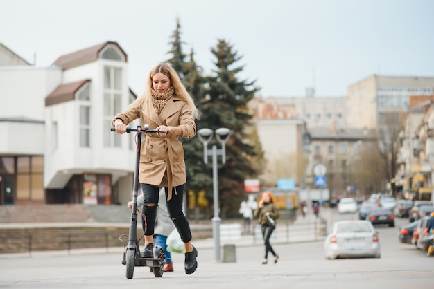 Giovane donna con scooter elettrico in città