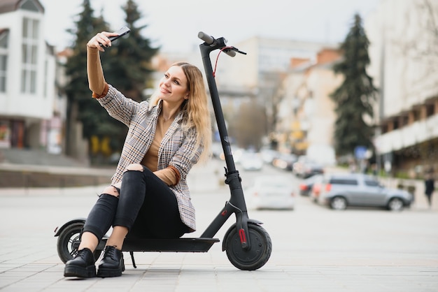 Giovane donna con scooter elettrico in città