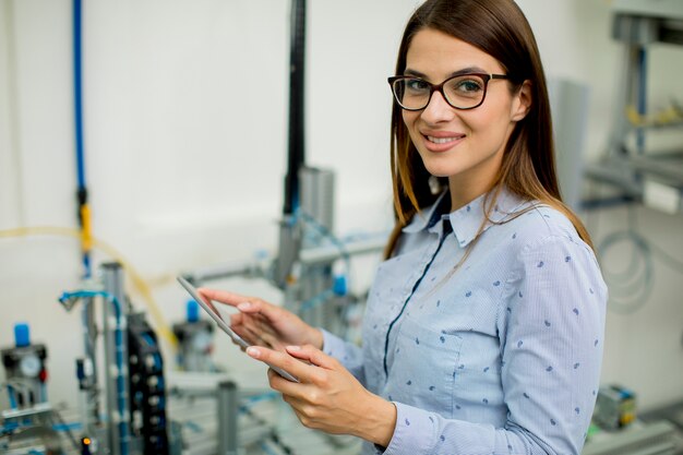 Giovane donna con tavoletta digitale nel laboratorio di elettronica