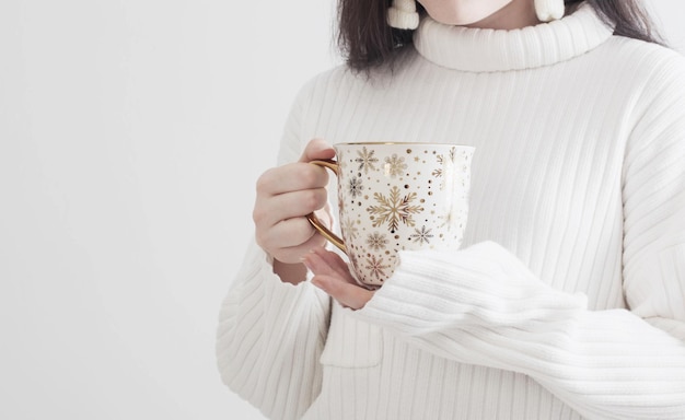 Giovane donna con tazza di Natale su sfondo bianco