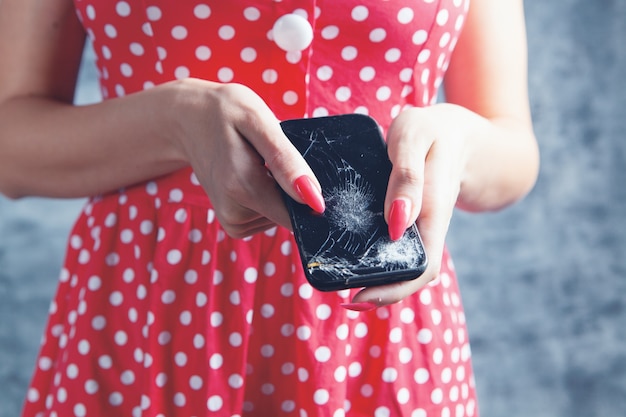 Giovane donna con telefono rotto