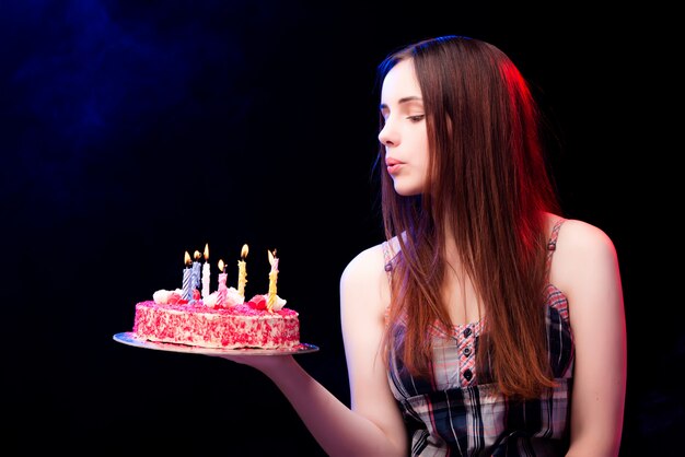 Giovane donna con torta di compleanno alla festa