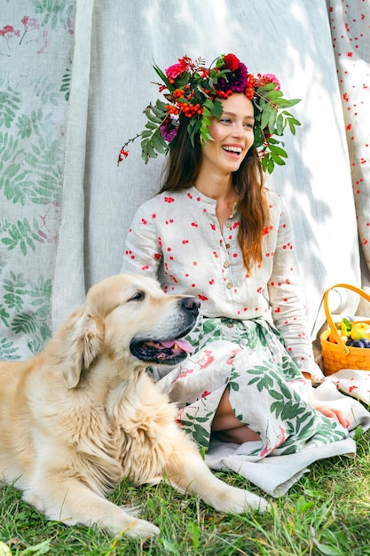 giovane donna con un cane e un cesto di frutta, prugne e mele.